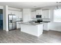 Bright kitchen features stainless steel appliances, central island and grey countertops at 6274 S Dean Rd, Buckeye, AZ 85326