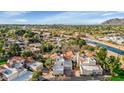 Aerial view of a residential neighborhood with lush greenery, a canal, and mountain views in the distance at 7800 E Lincoln Dr # 1104, Scottsdale, AZ 85250