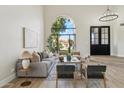 Bright living room with a soaring arch window, hardwood floors, contemporary furnishings, and stylish lighting at 9159 N 108Th Pl, Scottsdale, AZ 85259