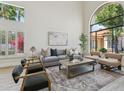 Bright living room with a soaring arch window, hardwood floors, contemporary furnishings, and stylish lighting at 9159 N 108Th Pl, Scottsdale, AZ 85259