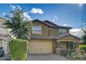 Attractive two-story home with a 2-car garage, set against a sunny sky, showcasing well-maintained landscaping at 10249 E Kinetic Dr, Mesa, AZ 85212