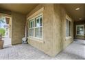 Inviting outdoor patio featuring stylish pavers, stucco walls, and bright windows at 10249 E Kinetic Dr, Mesa, AZ 85212