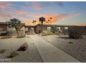 Charming desert landscaping accents this home with a sidewalk with lights leading to the front door at 10906 W Thunderbird Blvd, Sun City, AZ 85351