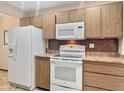 Functional kitchen with white appliances and wood-look cabinets and countertop at 10906 W Thunderbird Blvd, Sun City, AZ 85351