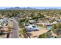 Scenic aerial view of the property in a quiet neighborhood with mature trees and mountain views at 12836 N 60Th St, Scottsdale, AZ 85254