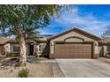 Charming single-story home showcasing a neutral color palette, attached garage, and low maintenance landscaping at 13238 W Market St, Surprise, AZ 85374