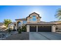 Elegant two-story home with a tile roof, three-car garage, and meticulously designed desert landscaping at 14052 S 24Th Way, Phoenix, AZ 85048