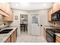 Well-lit kitchen featuring granite countertops, sleek black appliances, and tiled backsplash at 14209 N Palm Ridge Dr, Sun City, AZ 85351