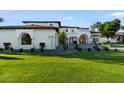 Lush green lawn and professional landscaping highlight the architectural details of this stunning estate at 1523 E Treasure Cove Dr, Gilbert, AZ 85234