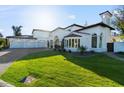 Beautifully landscaped front yard leads to the impressive facade of this luxury property with large windows at 1523 E Treasure Cove Dr, Gilbert, AZ 85234