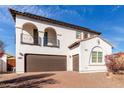 Charming two-story home with balconies, desert landscaping, and a brown two-car garage at 18268 W Carol Ave, Waddell, AZ 85355