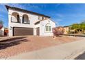 Charming two-story home with balconies, desert landscaping, and a brown two-car garage at 18268 W Carol Ave, Waddell, AZ 85355