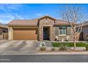 Charming single-Gathering home showcasing stone accents, a well-manicured lawn, and a welcoming two-car garage at 22858 E Marsh Rd, Queen Creek, AZ 85142