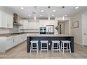 Modern kitchen with stainless steel appliances, a large island with seating, and white cabinetry at 22858 E Marsh Rd, Queen Creek, AZ 85142