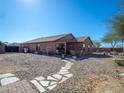 The backyard features a gravel-covered space, patio furniture, BBQ and a desert landscaped border at 23882 W Yavapi St, Buckeye, AZ 85326