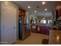 Spacious kitchen featuring a stainless steel refrigerator, warm-toned cabinets, and recessed lighting at 23882 W Yavapi St, Buckeye, AZ 85326