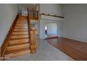 Inviting foyer with wooden staircase, tile flooring, and archway leading to the living spaces at 2542 S Playa --, Mesa, AZ 85202