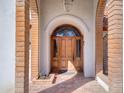 Close up view of a wooden arched doorway framed by brick pillars, creating a grand and inviting entrance at 2542 S Playa --, Mesa, AZ 85202