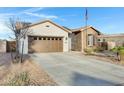 Home with a neutral stucco, stone facade, desert landscaping, and a spacious driveway at 303 S 197Th Ave, Buckeye, AZ 85326