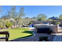 Stunning backyard featuring a putting green, outdoor kitchen, and serene mountain views at 31709 N 16Th Ave, Phoenix, AZ 85085