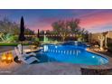 Resort-style backyard with a sparkling pool, lush landscaping, and ambient lighting for evening enjoyment at 31709 N 16Th Ave, Phoenix, AZ 85085