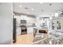 Bright kitchen featuring granite counters, stainless appliances, pendant lights, and white cabinets at 41921 N Crooked Stick Rd, Anthem, AZ 85086