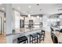 Bright kitchen featuring granite counters, stainless appliances, pendant lights, bar seating, and white cabinets at 41921 N Crooked Stick Rd, Anthem, AZ 85086