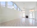 Bright living room featuring high ceilings, large windows, and a cozy fireplace at 4843 W Del Rio St, Chandler, AZ 85226