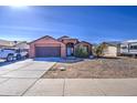 Single-story home with desert landscaping, an attached two-car garage, and a covered entryway at 5071 W Warren Dr, Casa Grande, AZ 85194