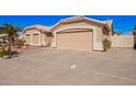 Tan home with a well-manicured yard, a large driveway, and an attached garage at 5462 W Geronimo St, Chandler, AZ 85226