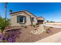 Charming home showcasing an attractive desert landscape and two-car garage, creating inviting curb appeal at 5550 N Luna Dr, Eloy, AZ 85131