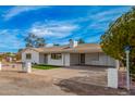 Beautiful white brick home with a covered carport and tidy landscaping, enhancing curb appeal at 6655 E Rustic Dr, Mesa, AZ 85215