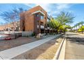 A brown and tan home with a sidewalk, partial wrought iron fence, and desert landscaping at 6745 N 93Rd Ave # 1166, Glendale, AZ 85305