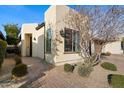 A contemporary home featuring desert landscaping, complemented by brick pavers and stylish outdoor lighting at 678 E Cobble Stone Dr, Queen Creek, AZ 85140