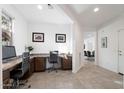 A well-lit home office featuring built-in desks with seating for two and neutral tiling throughout at 678 E Cobble Stone Dr, Queen Creek, AZ 85140