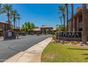 View of the community entrance and sign for The Plaza Residences with mature palm trees and lush landscaping at 7009 E Acoma Dr # 1046, Scottsdale, AZ 85254