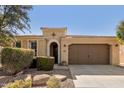 Charming single-story home with desert landscaping, a brown two car garage, and an arched entryway at 815 E Laddoos Ave, San Tan Valley, AZ 85140