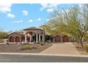 Beautiful home exterior with arched entryway, stone accents, fountain, and well-manicured desert landscaping at 8214 E Kael St, Mesa, AZ 85207