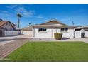 Inviting single-story home featuring a well-manicured lawn, and a freshly painted white exterior at 8432 E Keim Dr, Scottsdale, AZ 85250