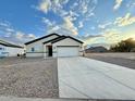 A single-story home is displayed with a long concrete driveway and low-maintenance gravel landscaping at 8477 W Tinajas Dr, Arizona City, AZ 85123