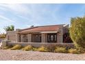 Charming single-story home with a red tile roof, inviting front porch and desert landscaping at 8544 E San Lorenzo Dr, Scottsdale, AZ 85258