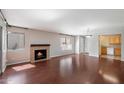 Open living room with fireplace, wood floors and view into kitchen at 10115 E Mountain View Rd # 1119, Scottsdale, AZ 85258