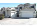 Lovely two-story home features two garages, a gray-tone exterior, and a well-manicured front yard at 10343 E Jacob Ave, Mesa, AZ 85209