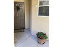 Inviting entryway featuring a brown door, welcoming mat, unit number, and a potted red flowering plant at 10410 N Cave Creek Rd # 1103, Phoenix, AZ 85020