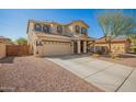 Two-story home with desert landscaping, a charming front porch swing, and a two-car garage at 16993 W Shiloh Ave, Goodyear, AZ 85338