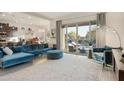 Inviting living room with backyard view, stylish blue seating, flowing into a kitchen and dining space at 18501 W Galveston St, Goodyear, AZ 85338