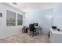 Bright office space featuring wood floors, blue accent wall, and ample natural light from a large window at 19259 N Ventana Ln, Maricopa, AZ 85138