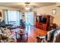 Bright living room with light colored walls, wood-look flooring, a ceiling fan, and access to the front entrance at 1926 E El Moro Ave, Mesa, AZ 85204