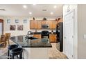 Modern kitchen featuring granite countertops, a breakfast bar, stainless steel appliances, and wood cabinets at 20207 N Riverbank Rd, Maricopa, AZ 85138