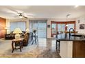 Spacious living room featuring tile flooring, a ceiling fan, large windows and access to the dining area at 20207 N Riverbank Rd, Maricopa, AZ 85138